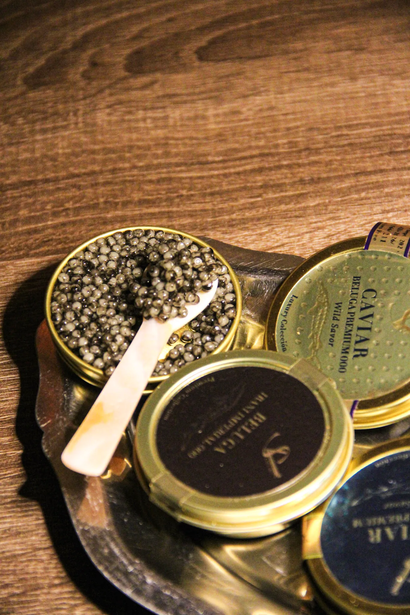 Caviar beluga con cuchara de nácar sobre madera oscura