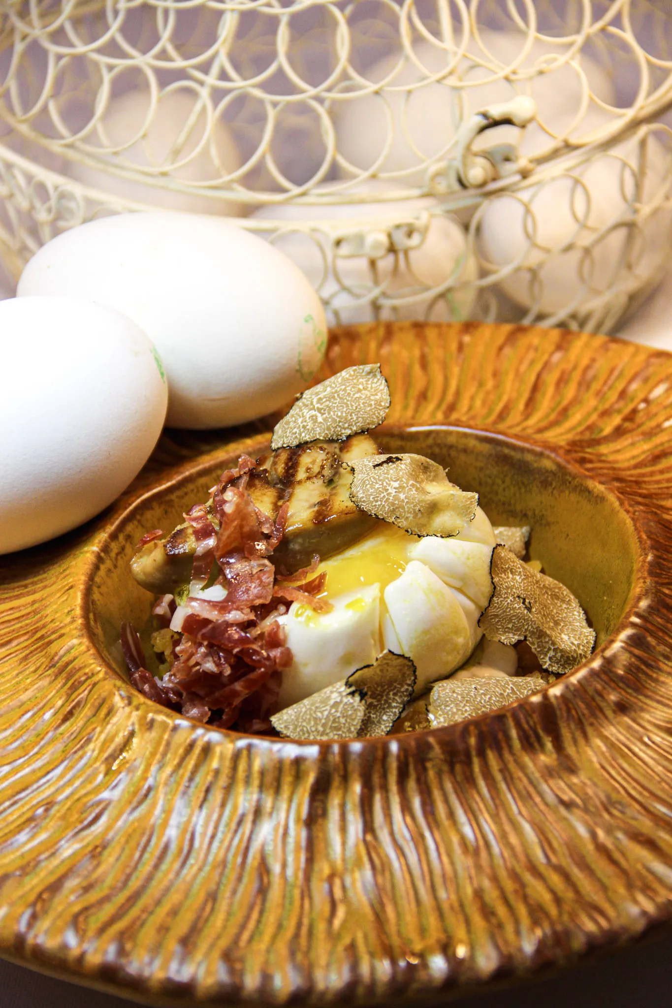 Huevo con trufa y jamón en cuenco dorado